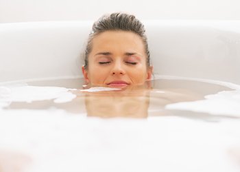 For a total immersion bath, fill the tub with warm water and submerge yourself as much as possible for 20-30 minutes